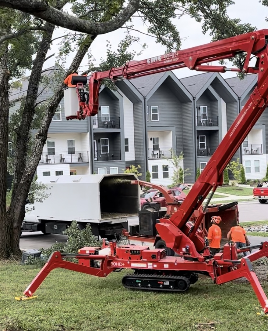 Tree Giants spider lift staged in front of a Nashville apartment community for tree trimming